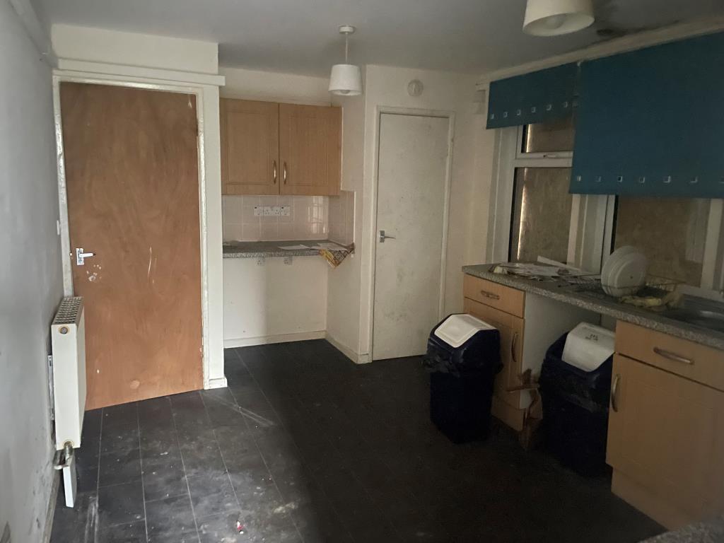 Lot: 110 - PROPERTY ARRANGED AS TWO FLATS - Kitchen for 11 Trevose Road with units, radiators and boarded up windows